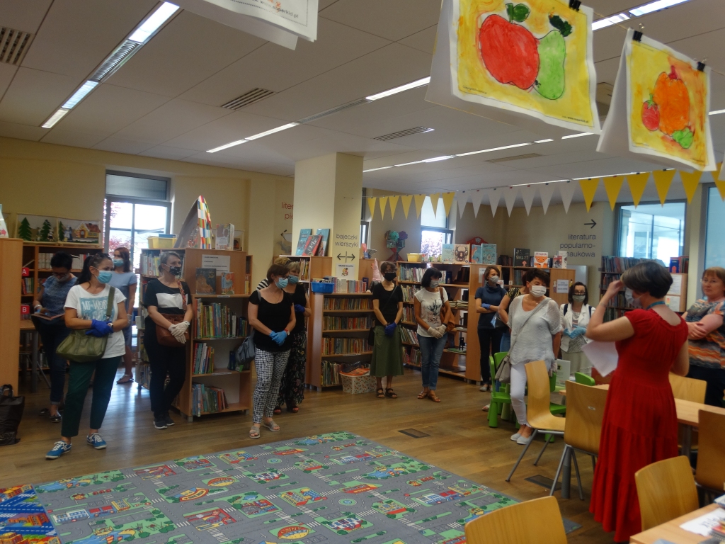 Grupa bibliotekarek w przestronnej i jasnej sali, wktórej mieści się wypożyczalnia dla dzieci