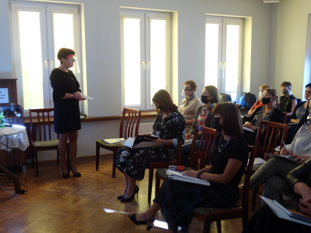 Dyrektor biblioteki Dorota Rzepka zwrócona w kierunku grupy siedzących kobiet