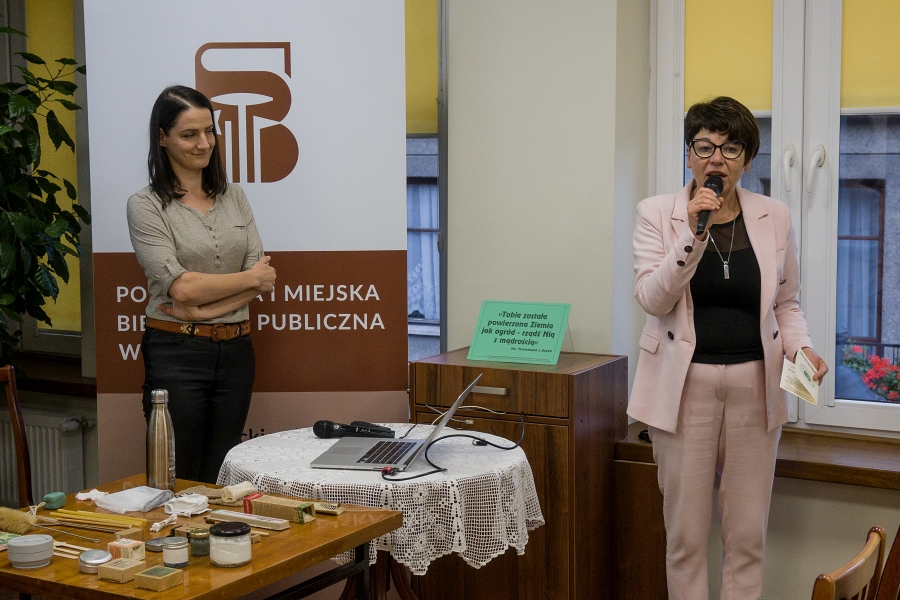 Aktywistka ekologiczna Anna Jaklewicz na tle banera z logo biblioteki obok dyrektor biblioteki dorota Rzepka