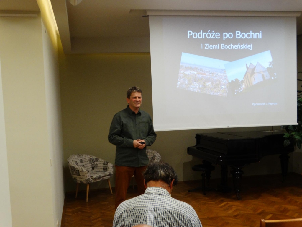 Janusz Paprota stojący obok ekranu 