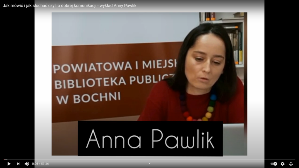 Psycholog Anna Pawlik na tle banera z logo biblioteki