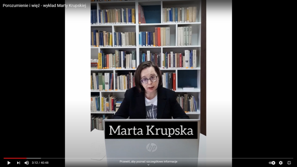 Marta Krupska siedząca przed ekranem laptopa. W tle regał z książkami.