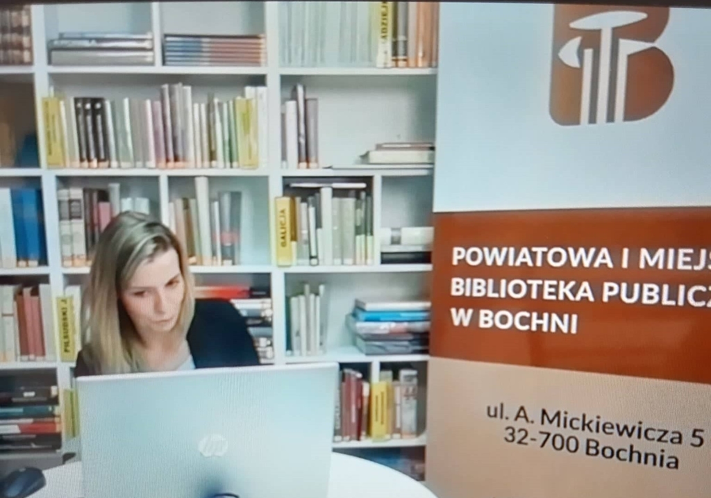 Patrycja Curyło-Sikora psycholog, psychoterapeuta i nauczyciel akademicki przed ekranem laptopa. Z boku baner z logo biblioteki