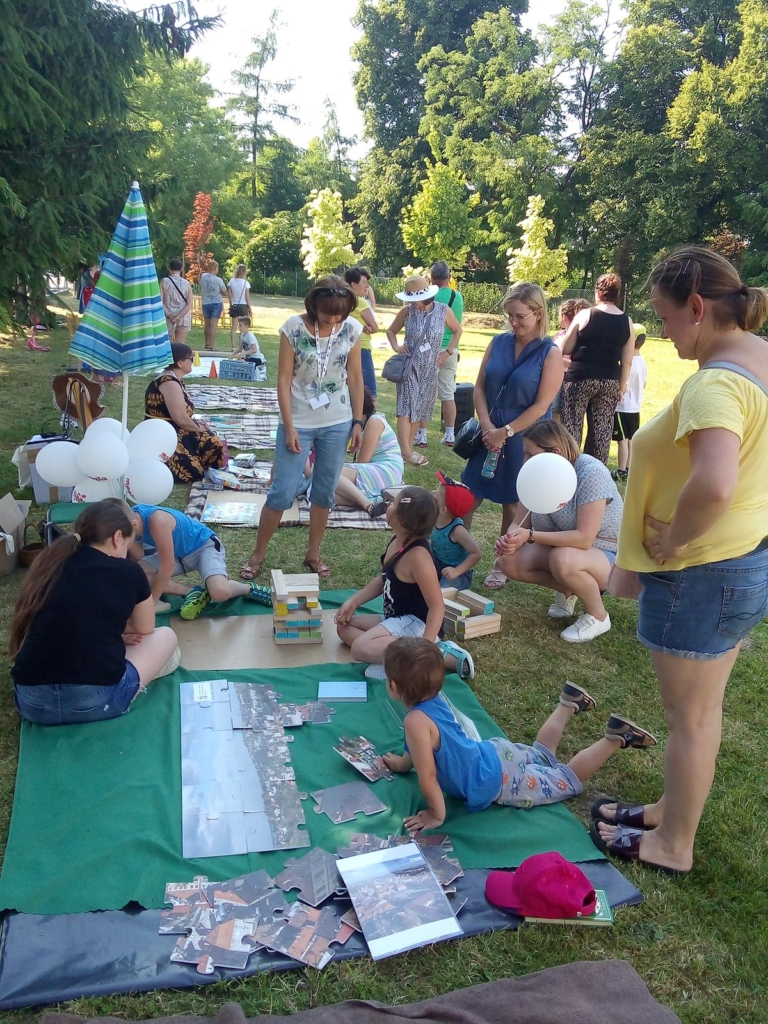 uczestnicy pikniku podczas układania puzzli, gry w jengę oraz w czytelni pod chmurką