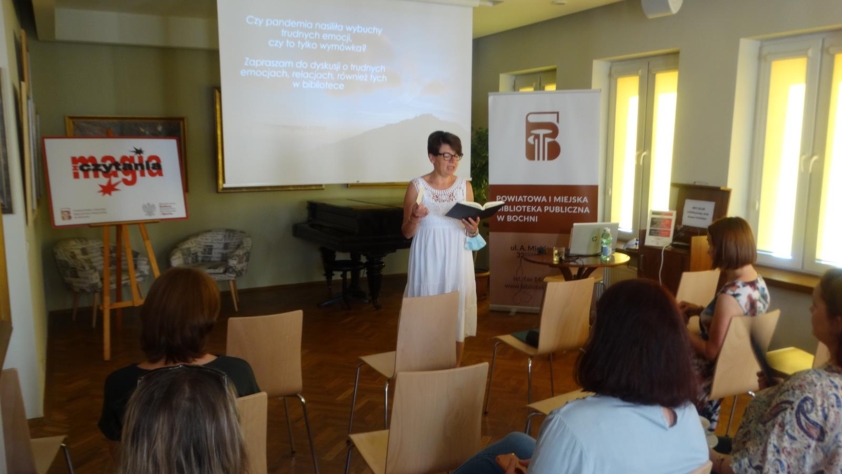 Dyrektor Biblioteki Dorota Rzepka na tle ekranu i logo projektu Magia z czytania