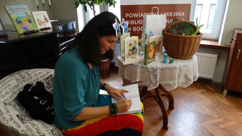 Małgorzata Swędrowska wpisuje dedykację do książki