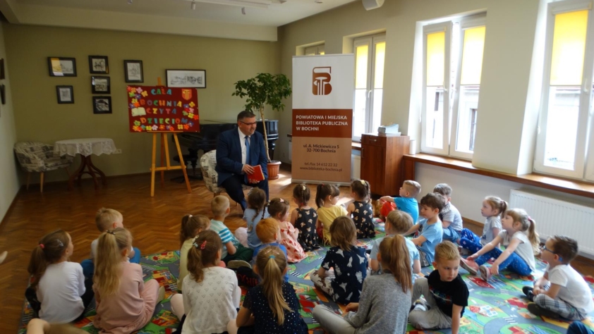 Starosta Bocheński Adam Korta czyta dzieciakom w Sali klubu Biblioteki