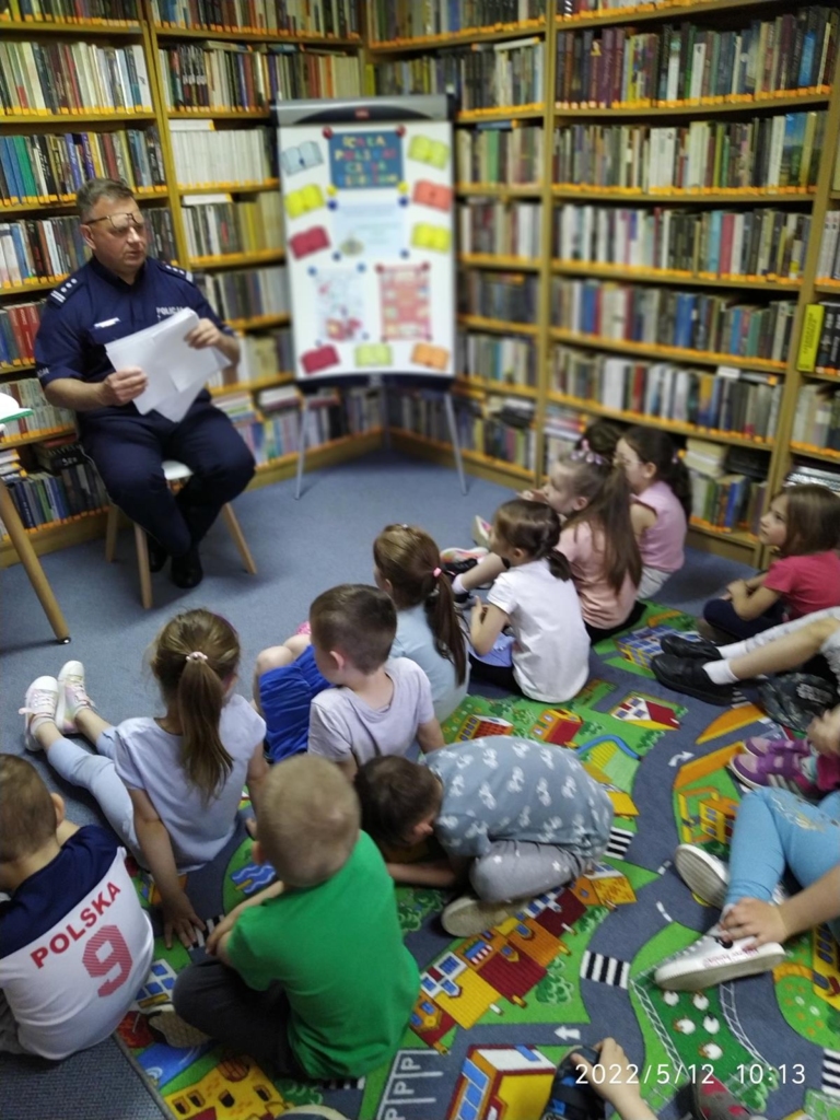Jerzy Polczyk komendant KPP w Bochni czyta dzieciom zgromadzonym w filii nr 6