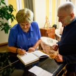 Aleksandra Mączka wpisuje dedykacje jednemu z uczestników spotkania