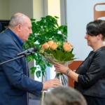 burmistrz Stefan Kolawiński wręcza bukiet róż dyrektorce biblioteki