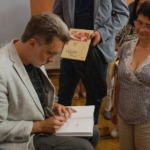 Michał Rusinek wpisuje dedykacje do książek
